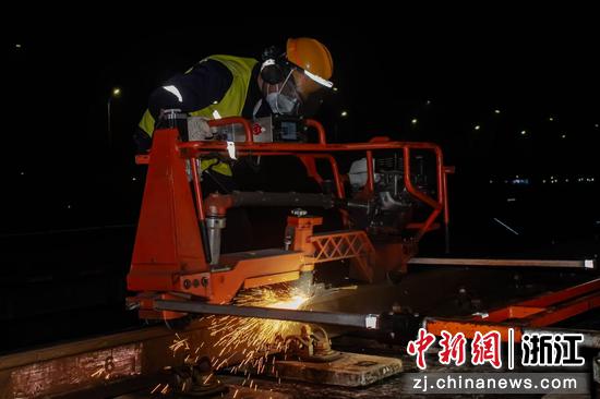 图为:工人在夜间对钢轨进行检修。中新社发 贺瑞明 摄