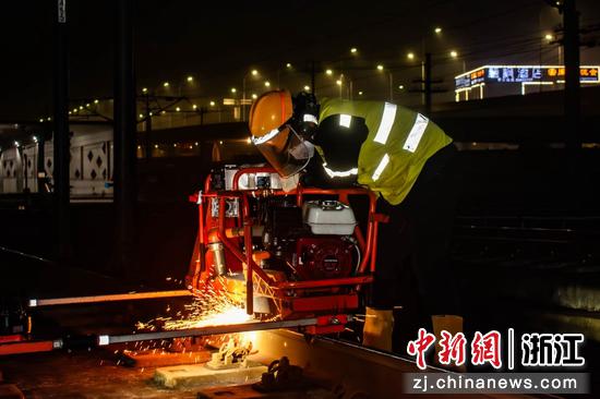 图为:工人在夜间对钢轨进行检修。中新社发 贺瑞明 摄