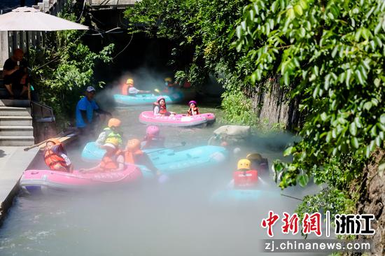 图为：游客在溪流中享受夏日时光。中新社发 张兴良 摄