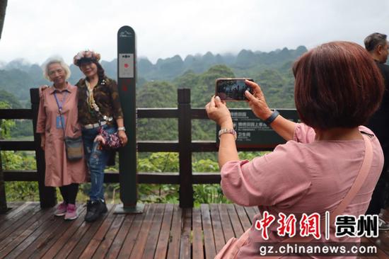 图为台胞正在万峰林景区拍照打卡。 图为台胞正在万峰林景区拍照打卡。