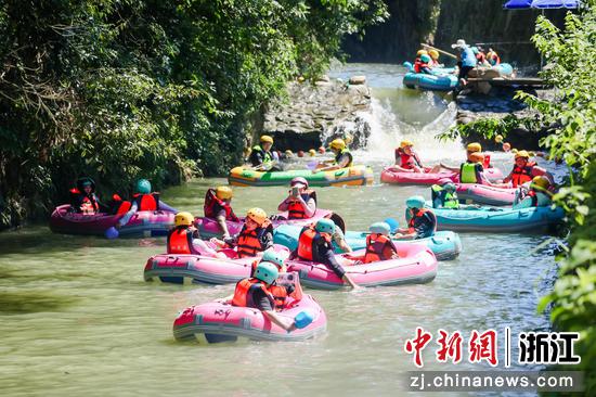 图为：游客在溪流中享受夏日时光。中新社发 张兴良 摄