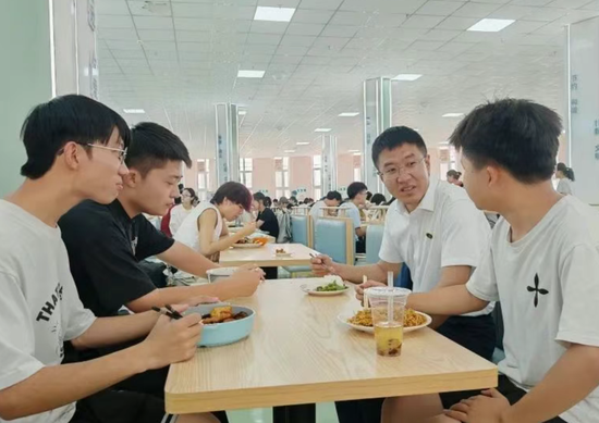 北京援疆教师邬津陪学生用餐,了解学习情况。古丽阿亚提 摄