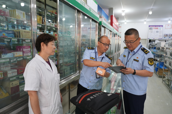 执法人员正在对药店药品进行检查。马合巴勒·木尔扎汗 摄