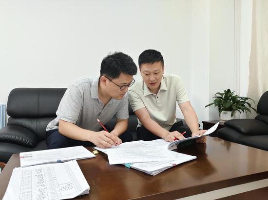 图为工作人员对照手册开展半年考核。黄心力 摄 图为工作人员对照手册开展半年考核。黄心力 摄