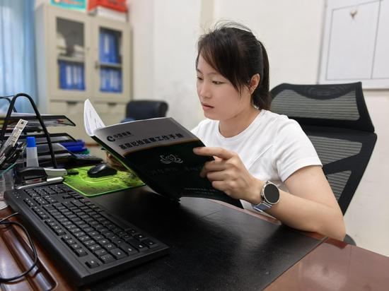 图为基层纪检监察员利用手册开展日常工作。石寅珊 摄 图为基层纪检监察员利用手册开展日常工作。石寅珊 摄