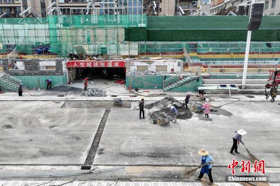 7月10日，工人在贵州“村超”球场开展灾后恢复建设工作。