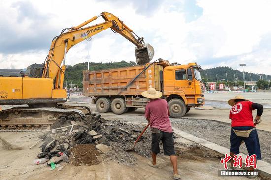 7月10日，工人在贵州“村超”球场开展灾后恢复建设工作。