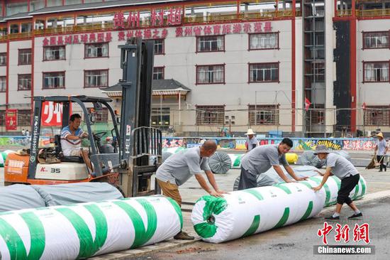 7月11日，工人在贵州“村超”球场整理爱心企业捐赠的草坪。