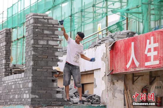 7月10日，工人在贵州“村超”球场开展灾后恢复建设工作。