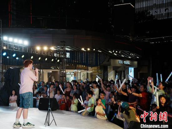 7月11日晚，来自英国的音乐人在贵阳路边音乐会演唱中文歌曲《月亮代表我的心》。中新网记者 周燕玲 摄