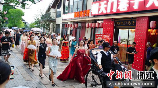新市古镇，由26人组成的“上海滩风云”巡游队伍与游客欢乐互动。大庆 摄