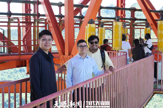 英国青年Ameer Ibrahim(中)与伙伴走上坝陵河大桥玻璃栈道,体验在370米的高空“云端漫步”。周璇 摄 英国青年Ameer Ibrahim(中)与伙伴走上坝陵河大桥玻璃栈道,体验在370米的高空“云端漫步”。周璇 摄