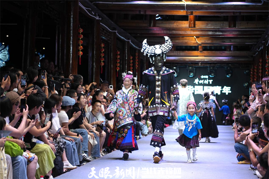 肯尼亚青年Nhial Deng身着苗族服饰与当地群众一起登上“村T”走秀。 周璇 摄 肯尼亚青年Nhial Deng身着苗族服饰与当地群众一起登上“村T”走秀。 周璇 摄