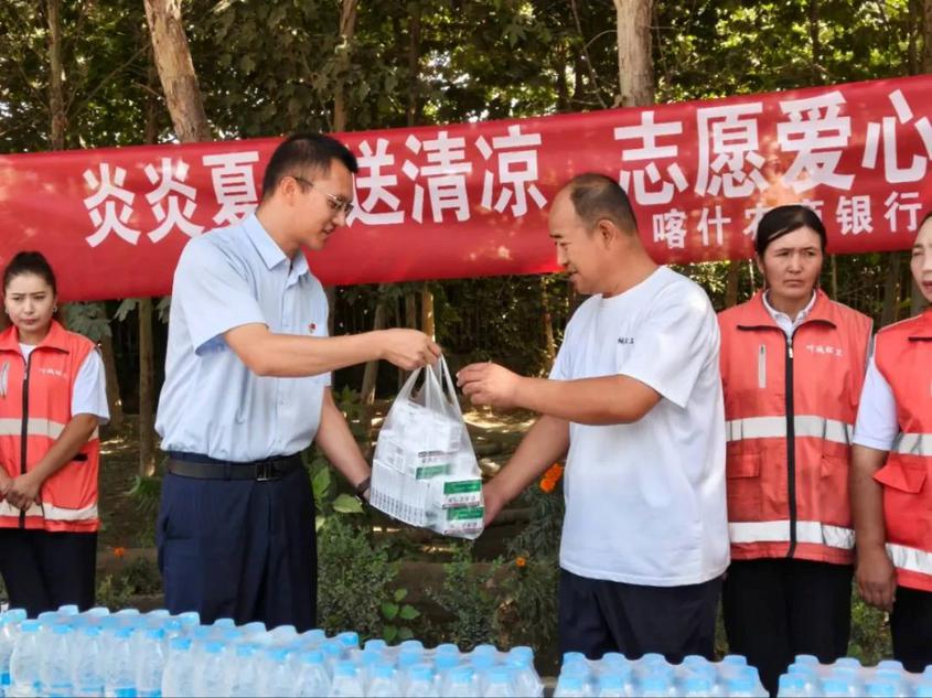 喀什农商银行叶城支行副行长何亮向环卫中心东片区负责人递上装有防暑药品的物资袋,传递夏日关怀。阿布都克热木·阿布都热西提 摄 喀什农商银行叶城支行副行长何亮向环卫中心东片区负责人递上装有防暑药品的物资袋,传递夏日关怀。阿布都克热木·阿布都热西提 摄