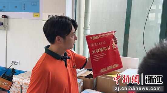 图为:杭州邮政滨江分公司高教揽投部经理赵金展示录取通知书。中新社发 韩颖 供图
