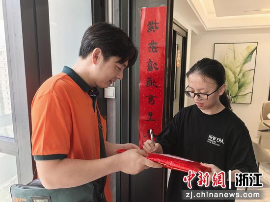 图为:学生(右)签收录取通知书。中新社发 韩颖 供图