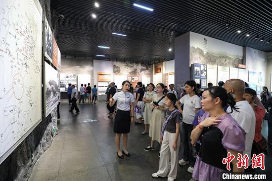 7月16日，游客在参观“中央红军第五次反‘围剿’要图”。暑假期间，位于贵州省遵义市红花岗区的遵义会议纪念馆游客络绎不绝。中新社记者 瞿宏伦 摄