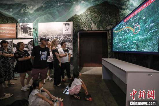 7月16日，游客在观看“遵义会议制定的战略计划”讲解视频。暑假期间，位于贵州省遵义市红花岗区的遵义会议纪念馆游客络绎不绝。中新社记者 瞿宏伦 摄