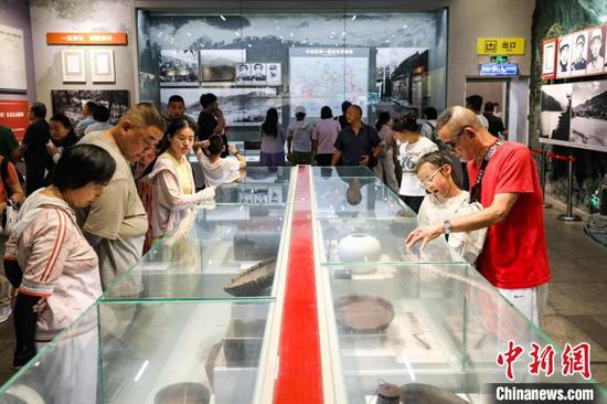7月16日，游客在参观红军使用过的物品。暑假期间，位于贵州省遵义市红花岗区的遵义会议纪念馆游客络绎不绝。中新社记者 瞿宏伦 摄
