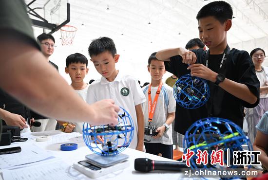 图为:工作人员赛前对无人机足球进行称重。中新社记者 王刚 摄