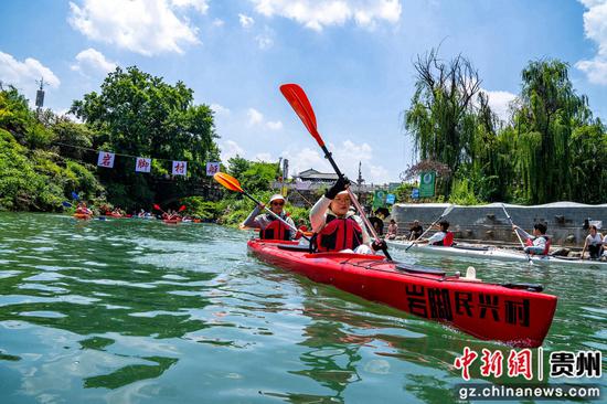 参赛队伍在岩脚古镇廻龙溪上挥桨竞渡。