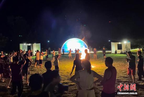 图为游客在贵州梵净山下的房车露营基地围着篝火跳舞。王婷婷 摄 图为游客在贵州梵净山下的房车露营基地围着篝火跳舞。王婷婷 摄