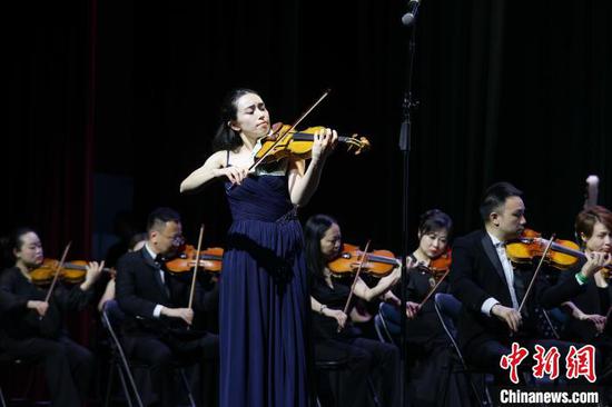 图为来自英国的小提琴演奏家格温妮丝·内尔梅斯和乐团合作演奏《冥想曲》。中新社记者 瞿宏伦 摄