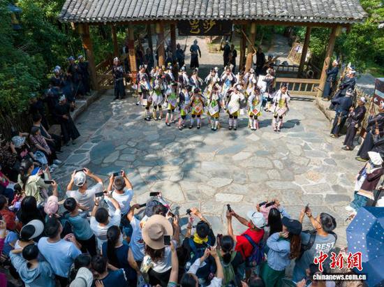 暑期以来,贵州省黔东南苗族侗族自治州从江县岜沙苗寨迎来旅游旺季,游客络绎不绝,前来苗寨游玩并体验独特的民俗文化。图为7月17日游客在岜沙苗寨观看迎宾仪式表演(无人机照片)。吴德军 摄 暑期以来,贵州省黔东南苗族侗族自治州从江县岜沙苗寨迎来旅游旺季,游客络绎不绝,前来苗寨游玩并体验独特的民俗文化。图为7月17日游客在岜沙苗寨观看迎宾仪式表演(无人机照片)。吴德军 摄