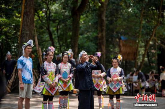 图为游客在岜沙苗寨参与苗族婚俗表演。吴德军 摄 图为游客在岜沙苗寨参与苗族婚俗表演。吴德军 摄