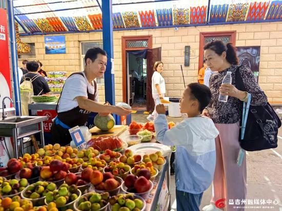 山坡村的阿米尔农家乐里游客在购买鲜切水果。记者王薇 摄