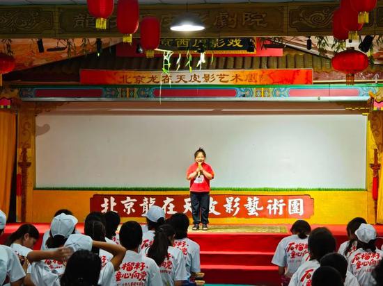 孩子们观看专业皮影剧团表演的经典剧目。