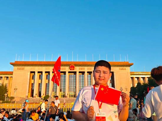 学生在天安门广场参加升国旗仪式后,在人民大会堂前拍照留念。
