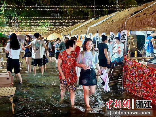 游客踩着水浪逛集市。（赤岸镇供图）