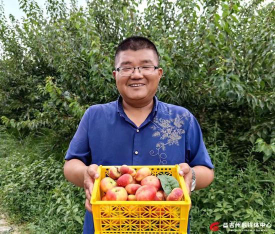 天池花果园负责人张缤捧着一筐鲜桃,脸上满是喜悦。记者王薇 摄