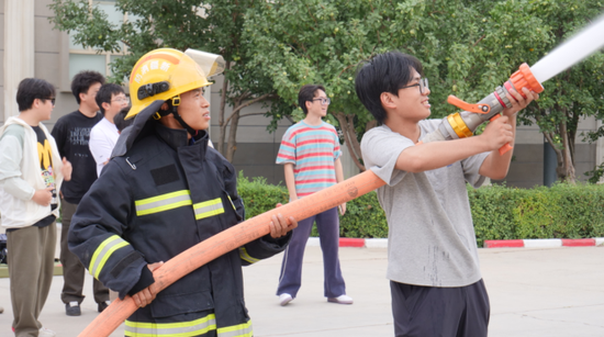 图为学生体验水枪。