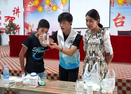 实践团老师向学生展示实验过程。 热依拉·阿迪力 摄