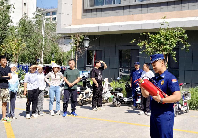 图为消防人员讲解灭火器使用方法。阿依古再丽  摄