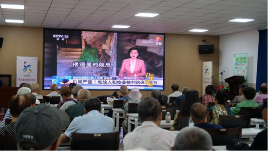 居民观看楼道隐患的宣传片。
