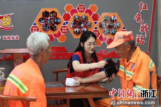 志愿者为环卫工人测量血压。胡子裕供图 志愿者为环卫工人测量血压。胡子裕供图