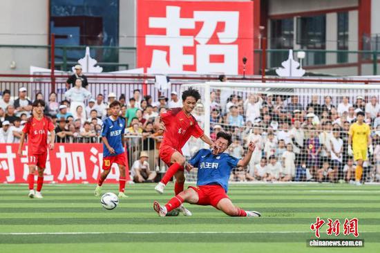 7月26日，榕江县东门村球员(红衣)和扒王村球员在比赛中。
