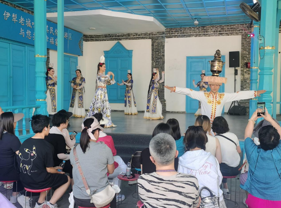7月23日，在新疆伊犁哈萨克自治州伊宁市伊犁老城喀赞其文化旅游区内，游客正欣赏舞蹈表演。李文婧 摄image
