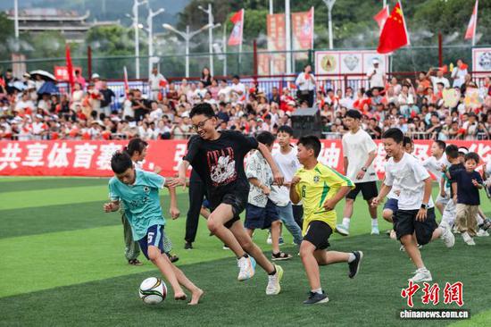 7月26日，中场休息时孩童在“村超”球场踢球。