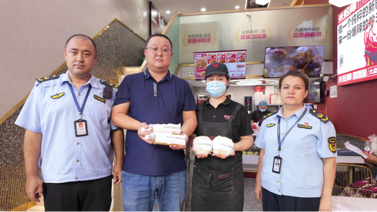 工作人员在米粉店内完成抽样的留影场景。