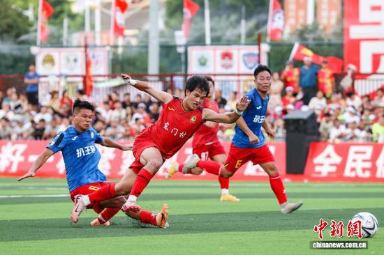 7月26日，榕江县东门村球员(红衣)和扒王村球员在比赛中。