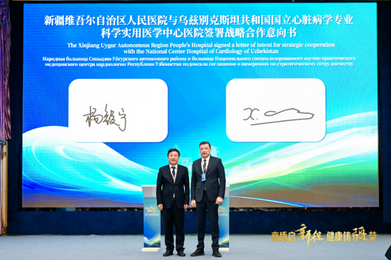 新疆维吾尔自治区人民医院党委副书记、院长杨毅宁(左)与乌兹别克斯坦国立心脏病学专业科学和实用医学中心医院院长库尔希迪·福兹洛夫(右)签署战略合作意向书。(活动方供图)