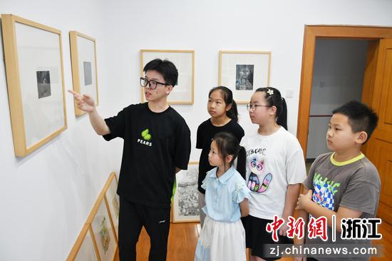 陈天涵（左一）为辖区的孩子们讲解画作。（招宝山街道供图）