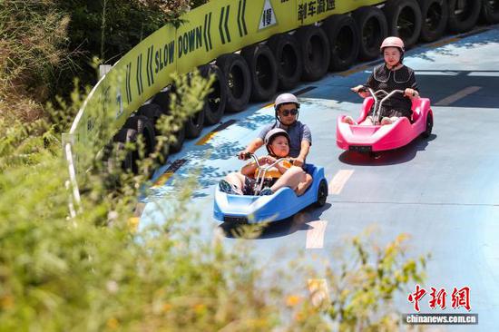 7月31日，游客在体验滑板车。中新社记者 瞿宏伦 摄