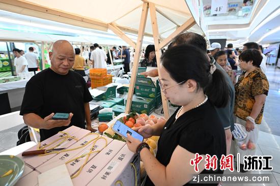 图为:采购商和果农联系洽谈。中新社记者 王刚 摄