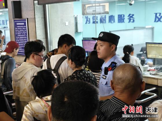 图为北京铁路公安局天津公安处天津站派出所民警在售票厅维持旅客购票、退票秩序。（北京铁路公安局天津公安处供图）
