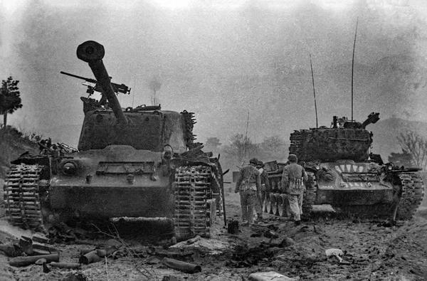 1951年4月24日，江口洞战役中，志愿军第20军178团潘泽民率领战斗小组，利用缴获美军的90火箭筒，近距离发射8发炮弹击毁美军坦克3辆后，又同另一射手配合击毁战车一辆，荣获“反坦克英雄”称号。图为潘泽民和战友们在打扫战场。  张崇岫 摄